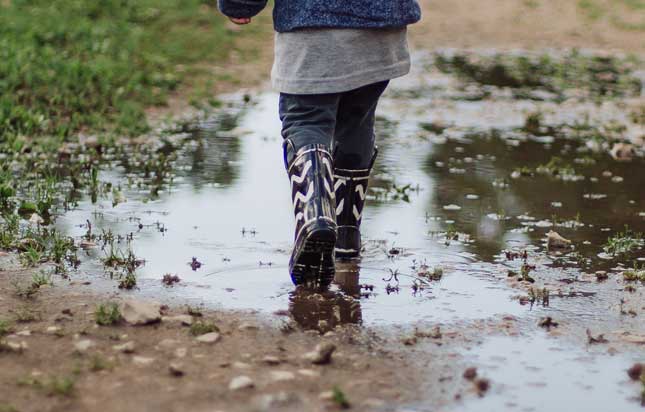 Child Walking Through Puddle